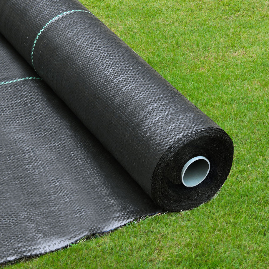 Roll of black weed barrier cloth on a grassy background